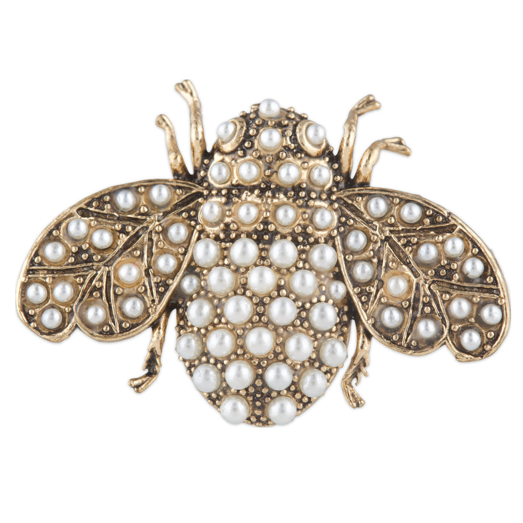 Gold insect-shaped brooch with pearl embellishments on a white background