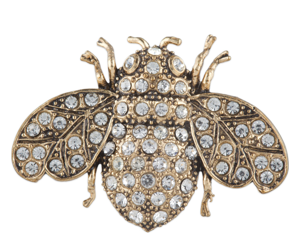 Gold bee-shaped brooch with crystal embellishments on a white background