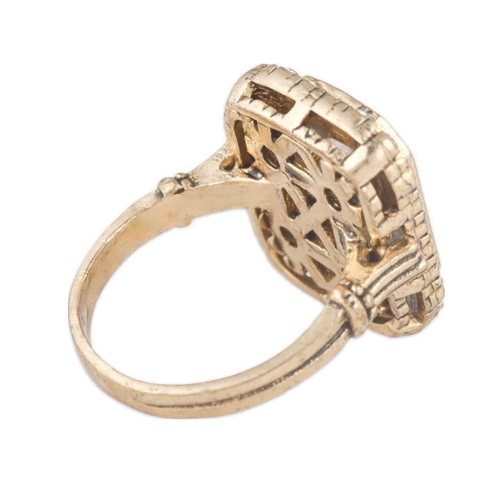 Gold ring with intricate design on a white background