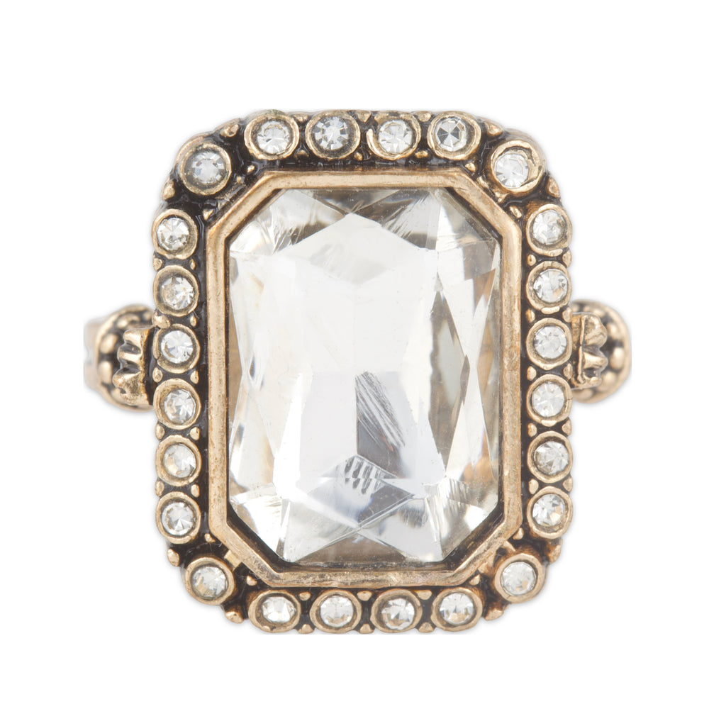 Ring with a large central gemstone and smaller stones around on a white background