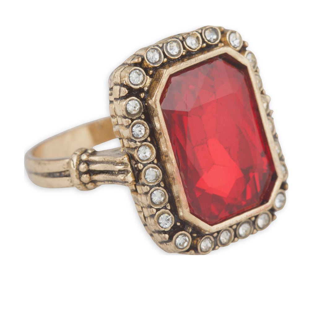 Ring with a red gemstone and gold-tone setting on a white background