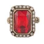 Ring with a red gemstone and gold border on a white background