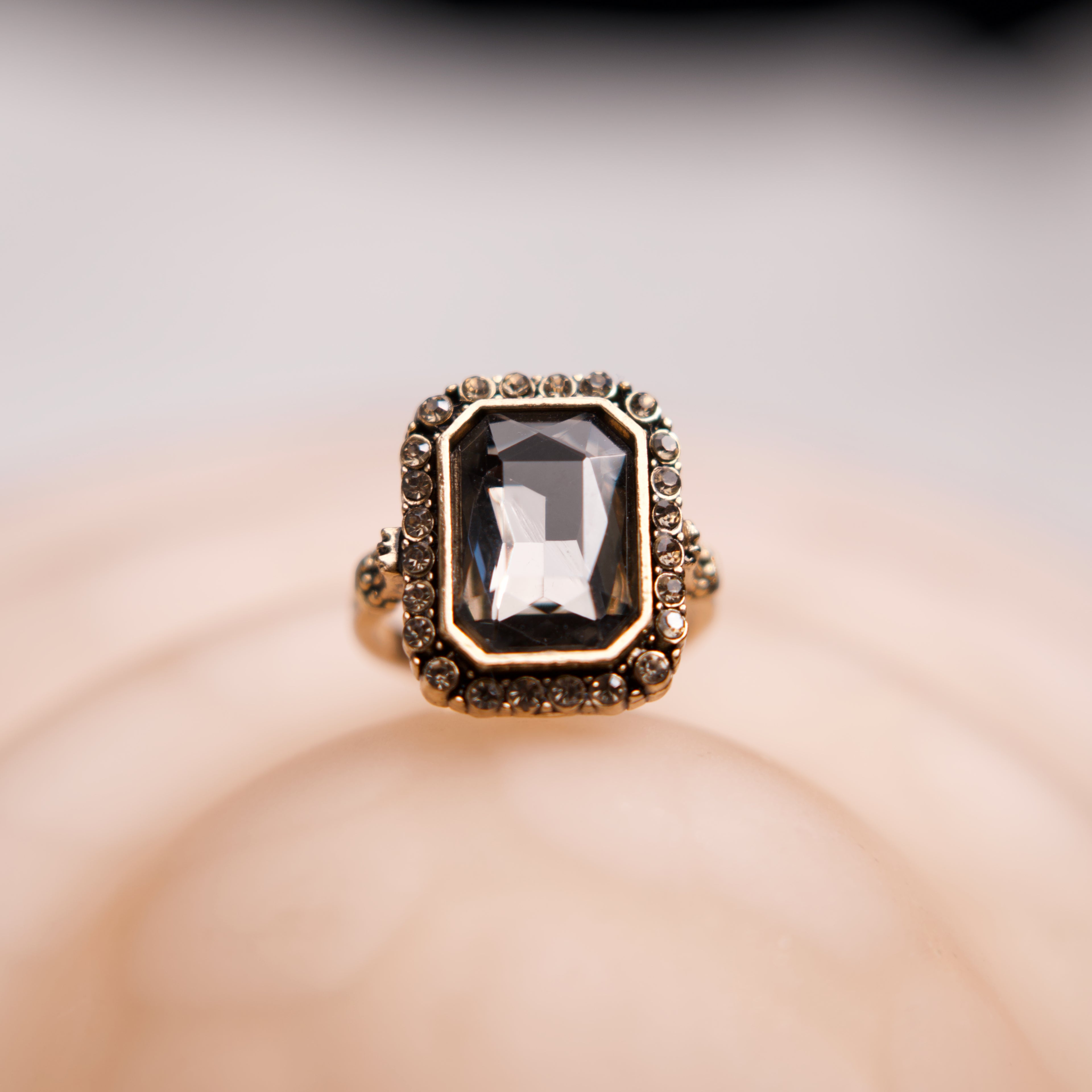 Gold ring with a large gemstone on a soft background