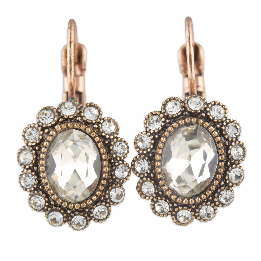 Pair of ornate earrings with clear gemstones and rose gold accents on a white background