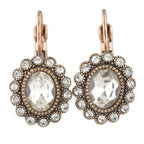 Pair of ornate earrings with clear gemstones and rose gold accents on a white background