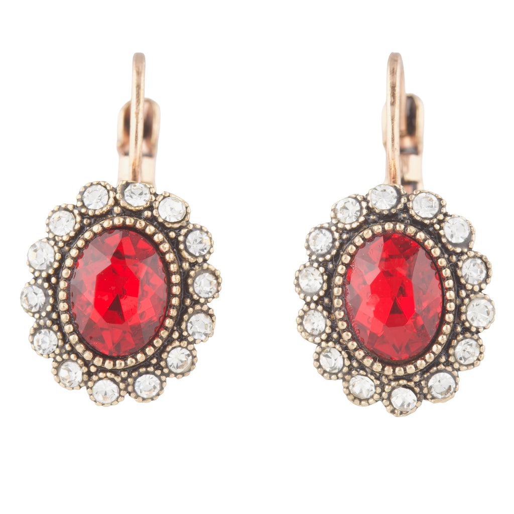 Pair of earrings with red gemstones and rose gold accents on a white background