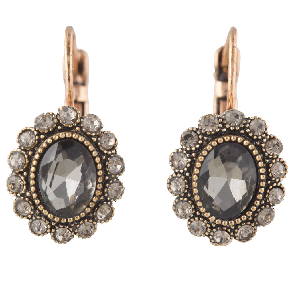 Pair of earrings with dark gemstones and gold accents on a white background