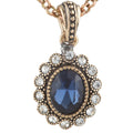 Rose gold necklace with a blue gemstone pendant on a white background