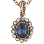 Rose gold necklace with a blue gemstone pendant on a white background