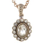 Rose gold necklace with a pendant featuring a large central gemstone and smaller stones around it on a white background.
