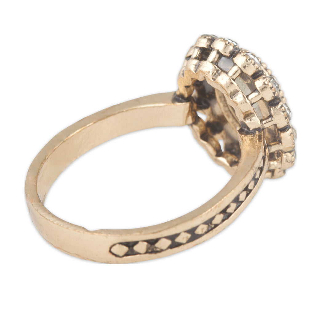 Gold ring with intricate design on a white background