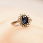 Gold ring with a blue gemstone on a beige background