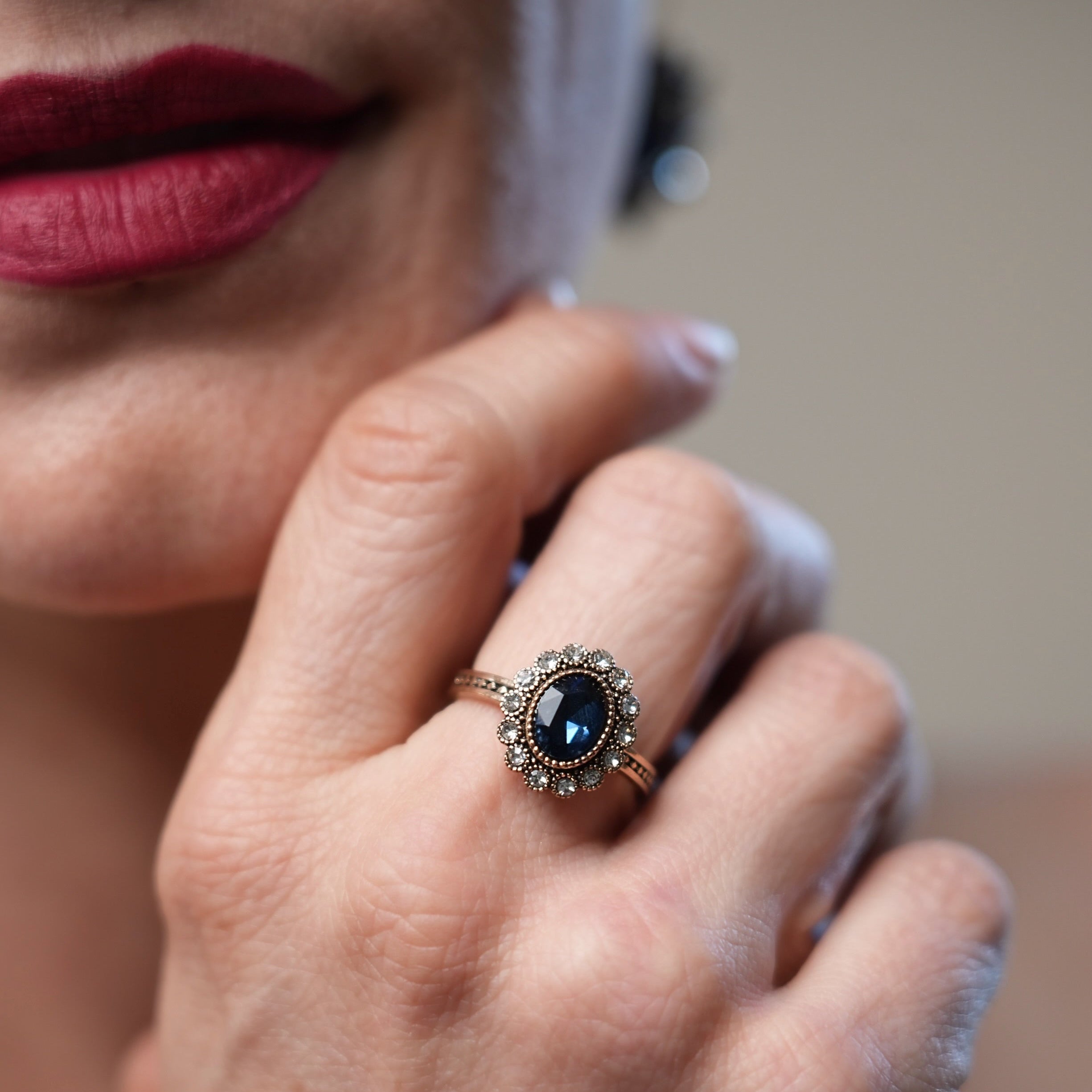 Close-up of a woman's hand wearing a ring with a dark gemstone.