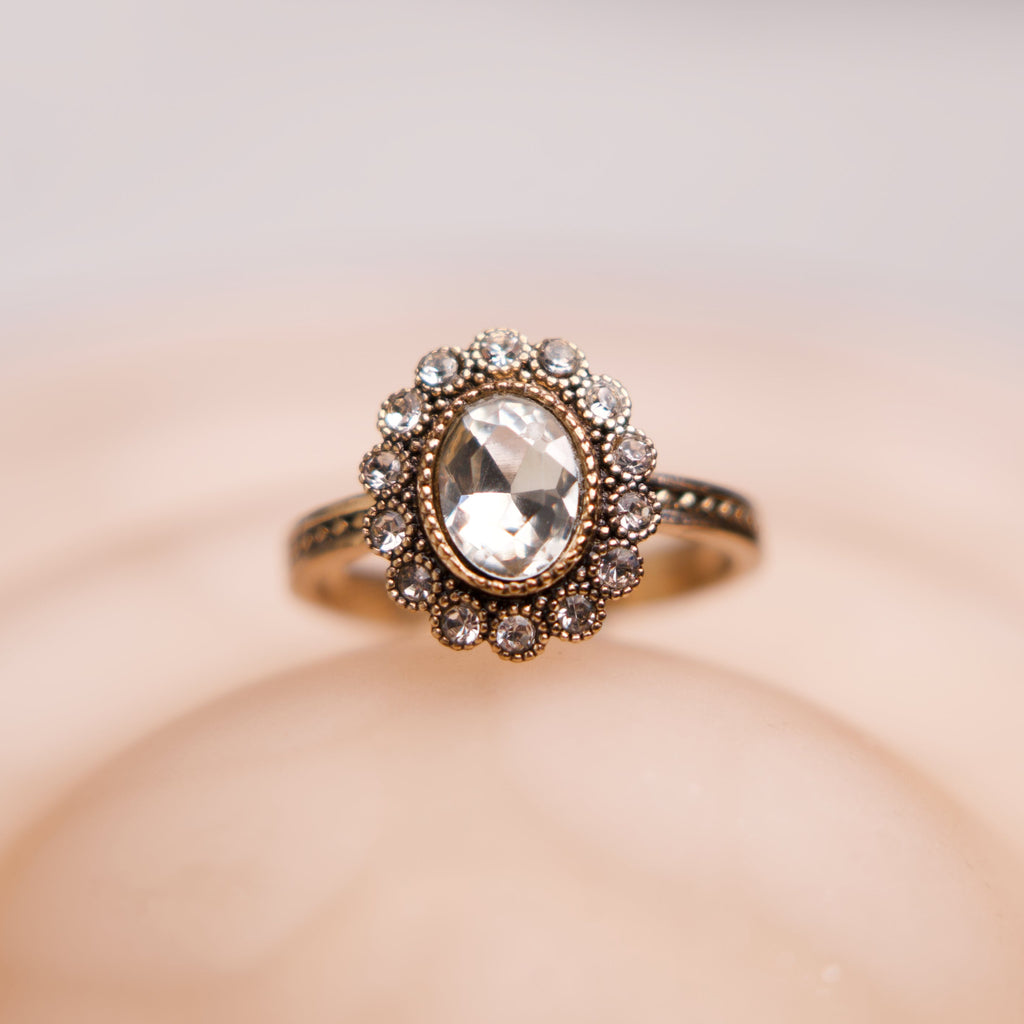 Elegant ring with a prominent gemstone on a soft beige background