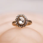 Elegant ring with a prominent gemstone on a soft beige background