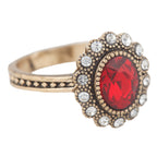 Ring with a red gemstone and gold accents on a white background
