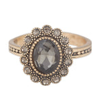 Gold ring with a central gray gemstone and smaller clear stones on a white background
