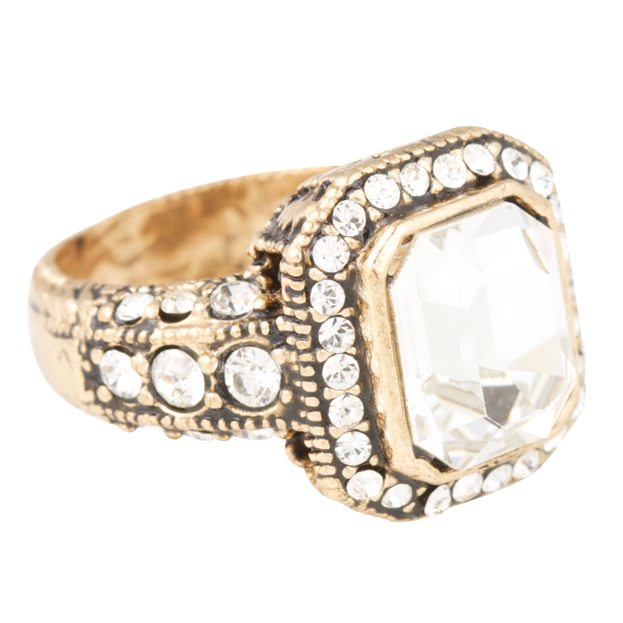 Gold ring with a large clear gemstone and smaller crystals on a white background