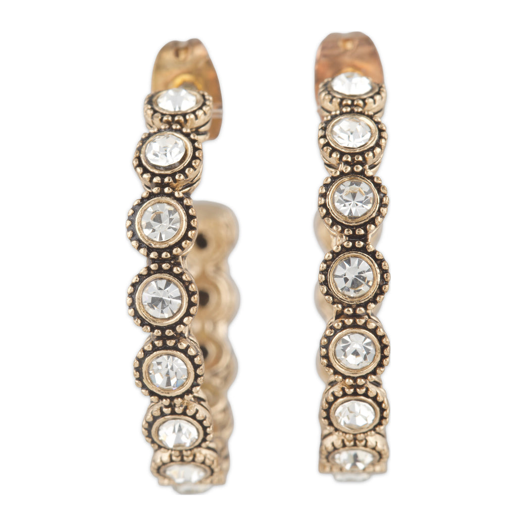 Pair of gold hoop earrings with embedded crystals on a white background