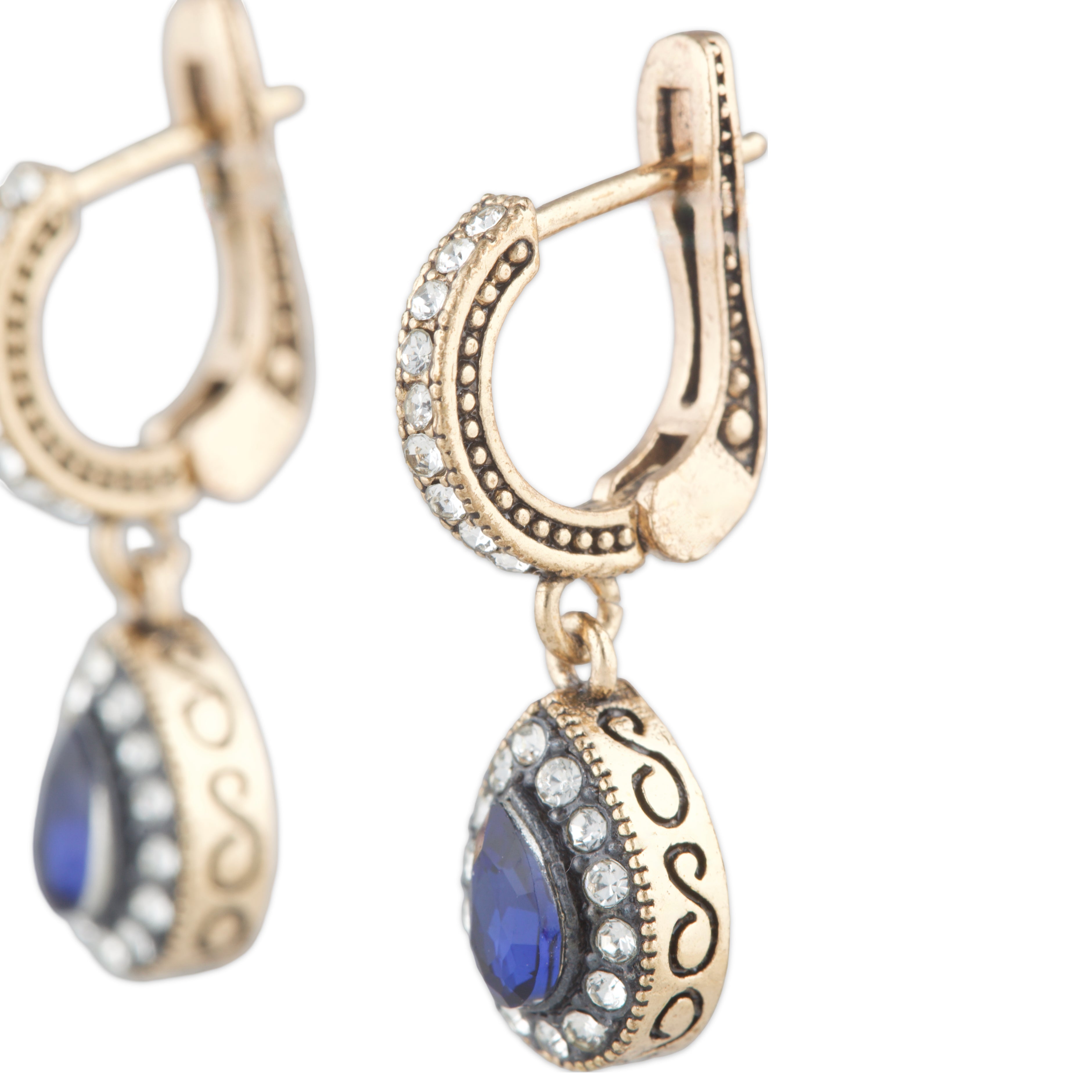 Gold earrings with blue stones and intricate designs on a white background