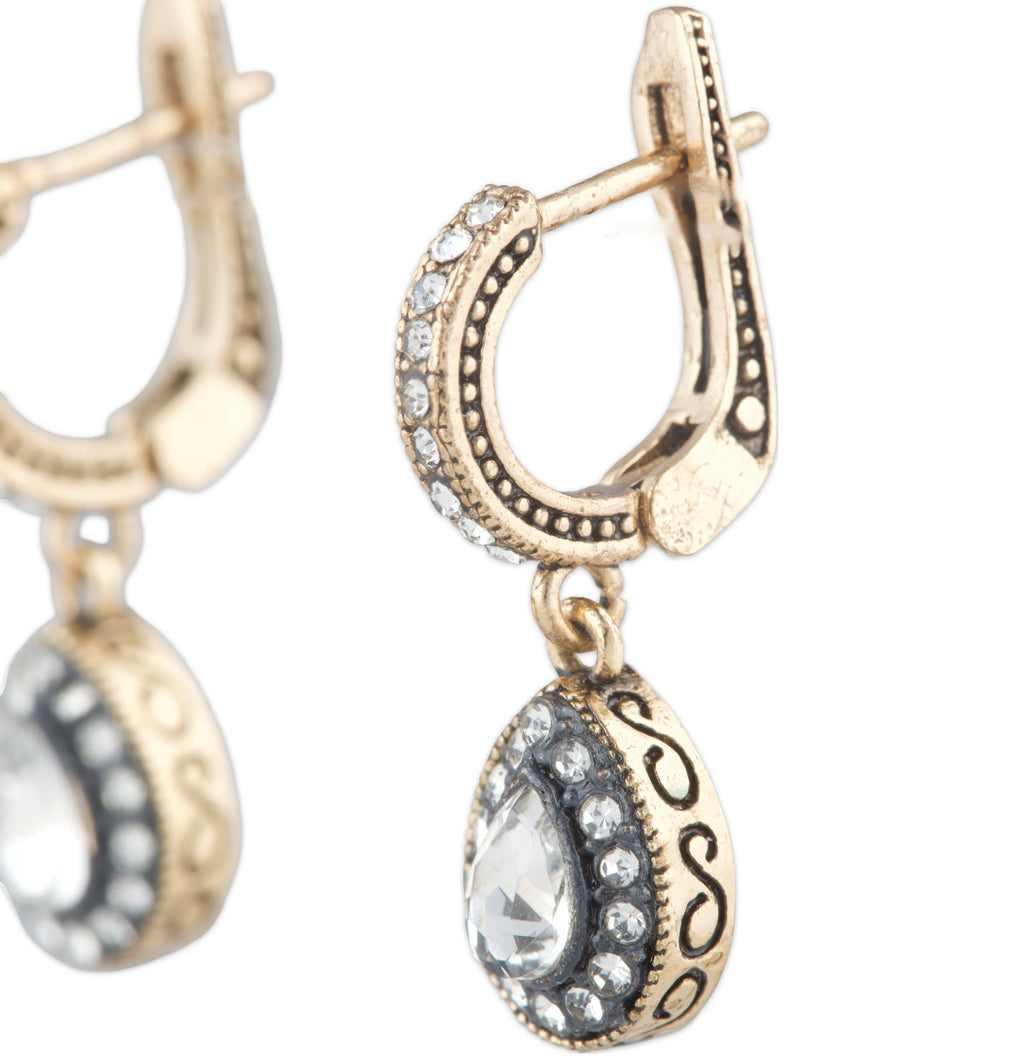 Gold hoop earrings with teardrop-shaped charms on a white background