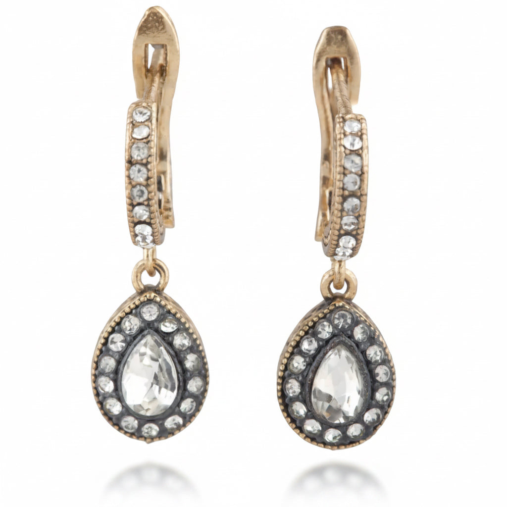 Pair of gold and silver earrings with teardrop-shaped gemstones on a white background