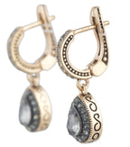 Gold hoop earrings with dangling beads on a white background