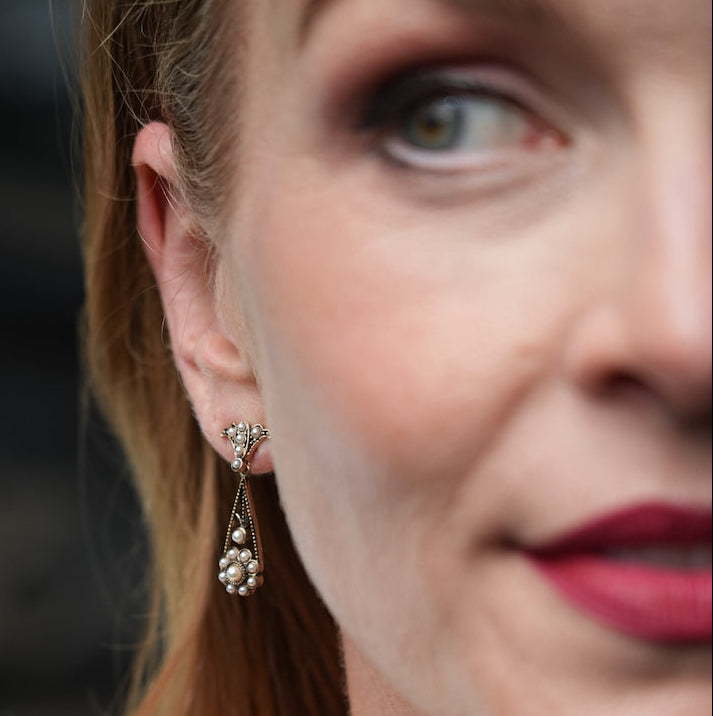 Close-up of a woman wearing a floral earring with a blurred background