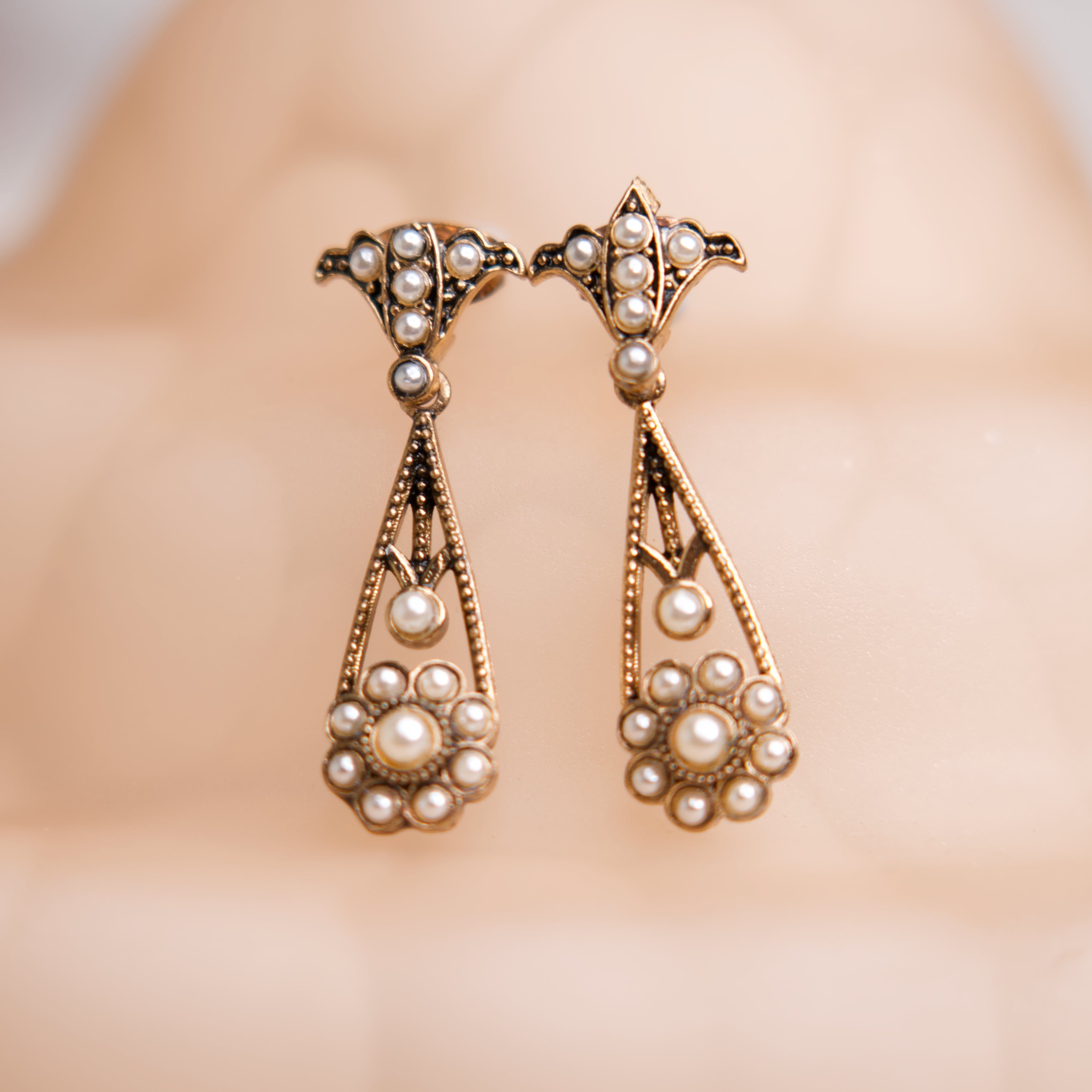 Pair of pearl earrings on a blurred background