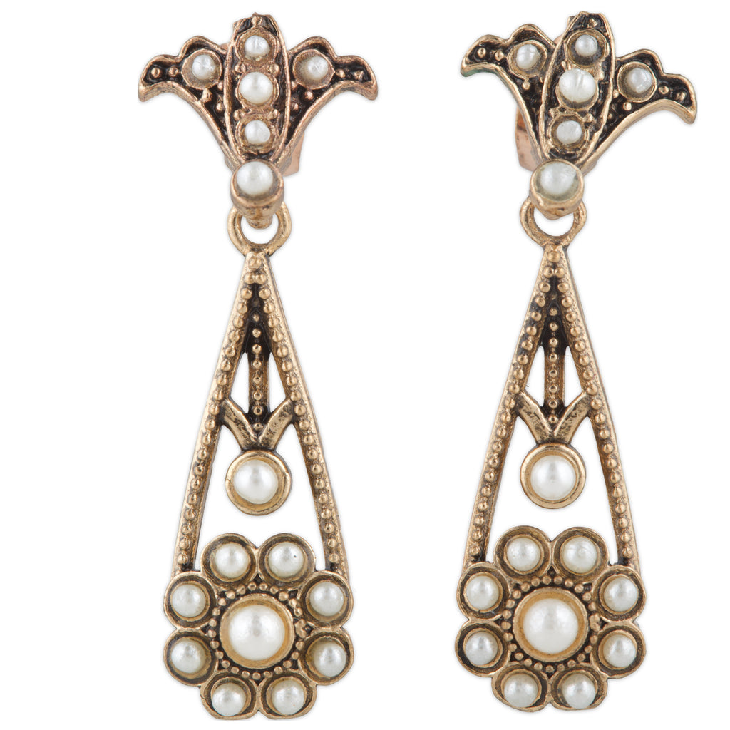 Pair of ornate earrings with pearl-like stones on a white background