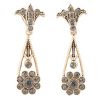 Pair of ornate earrings with gemstones on a white background