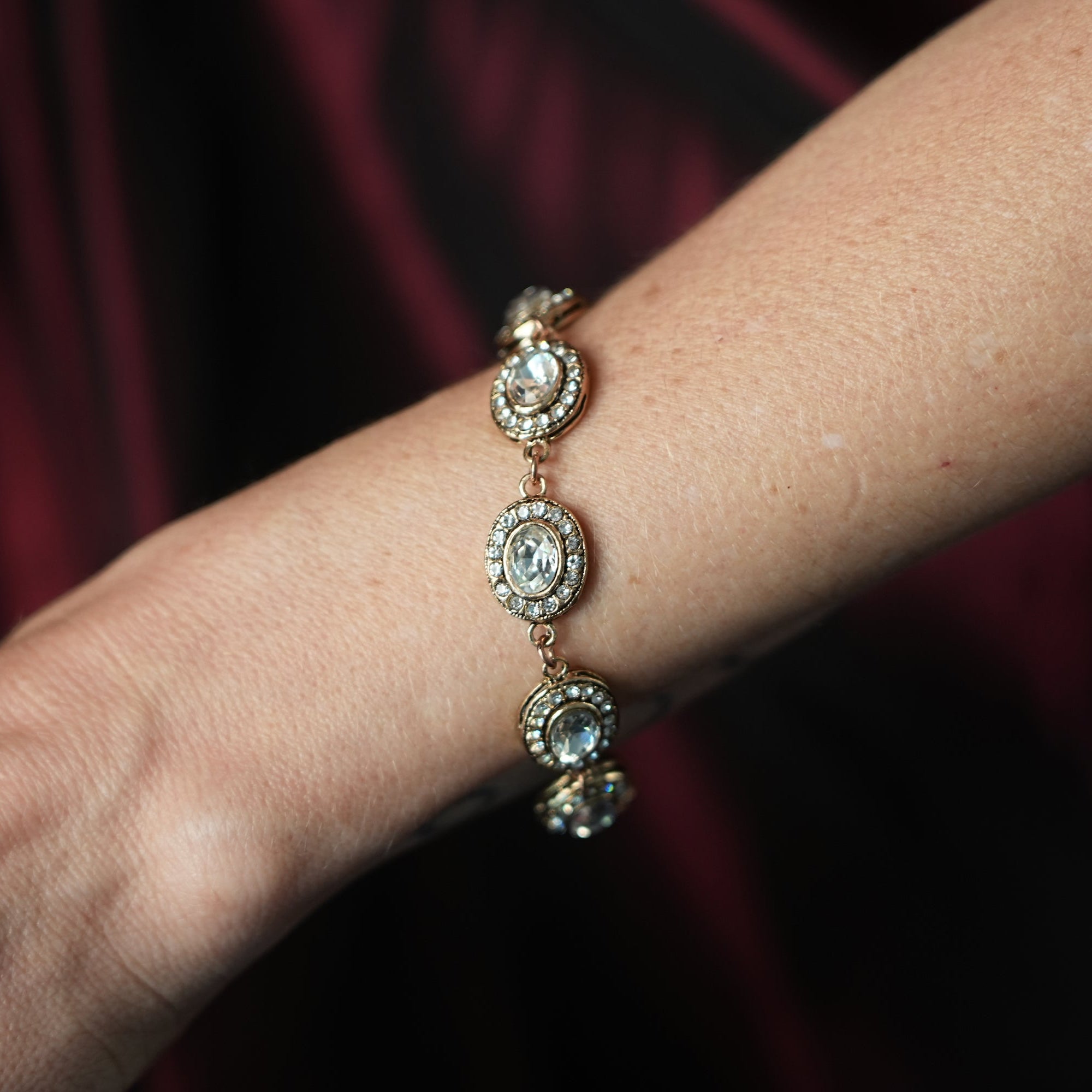 Close-up of a wrist wearing a diamond bracelet against a dark background