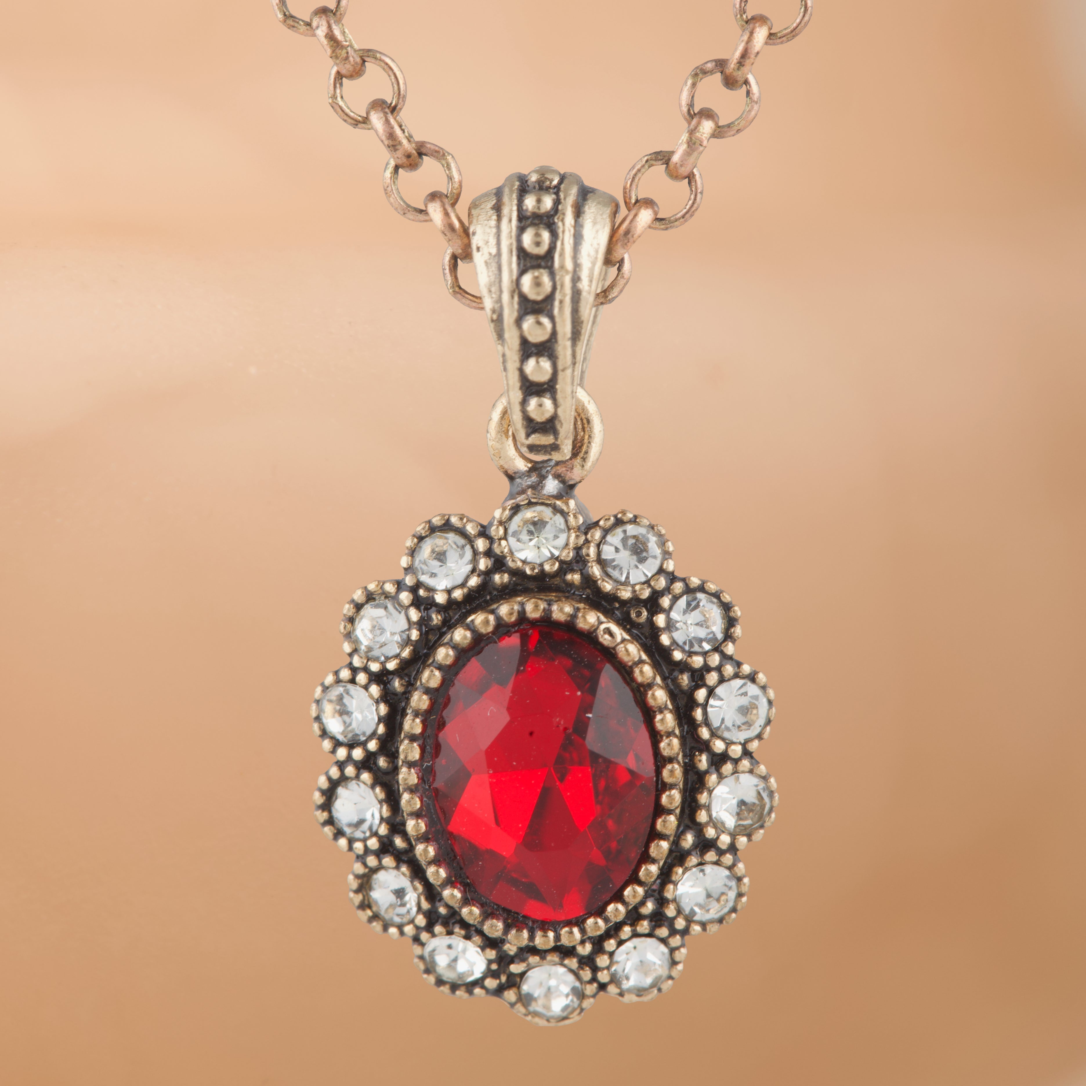 Necklace with a red gemstone pendant on a beige background