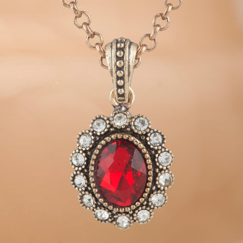 Necklace with a red gemstone pendant on a beige background