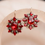 Pair of red gemstone earrings on a beige background