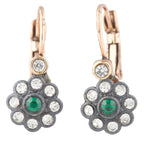 Pair of earrings with green gemstones and clear stones on a white background