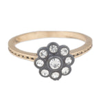 Gold ring with a black flower-shaped gemstone cluster on a white background