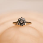 Flower-shaped diamond ring on a beige background