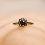 Floral ring with a central gemstone on a beige background