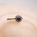 Decorative hairpin with a red gemstone and clear stones on a soft pink background