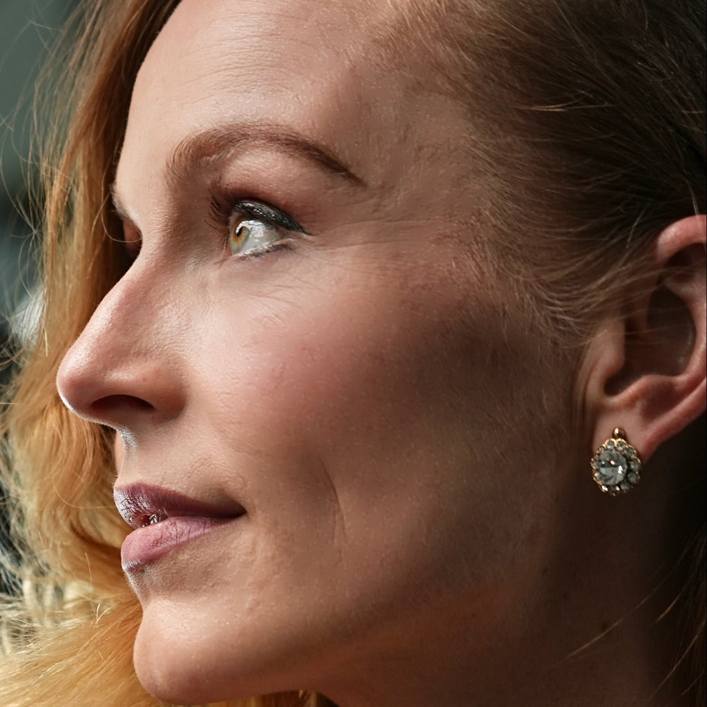 Close-up of a woman's face with a focus on her earrings.