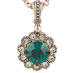 Gold necklace with a green gemstone pendant on a white background