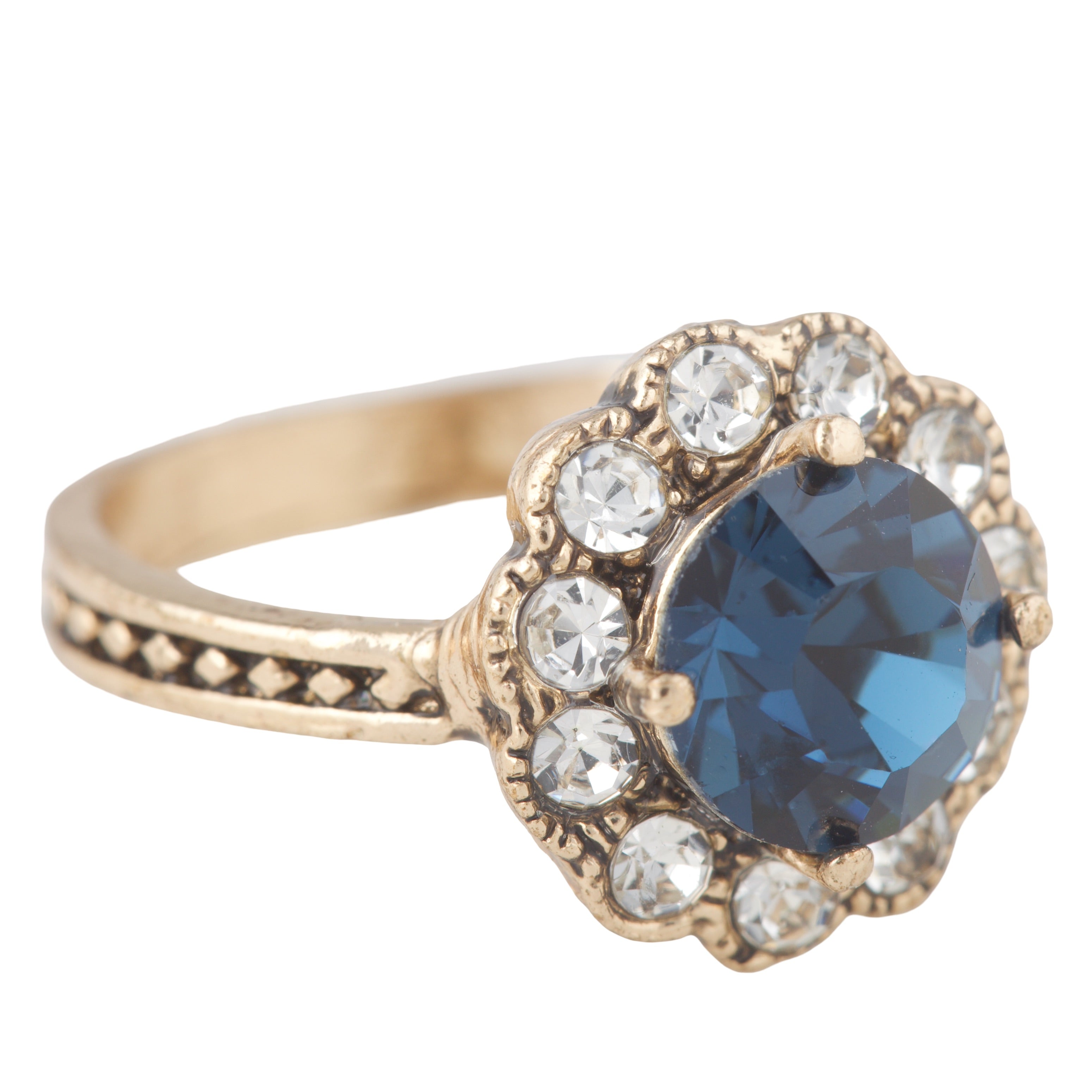 Gold ring with a blue gemstone and smaller clear stones on a white background
