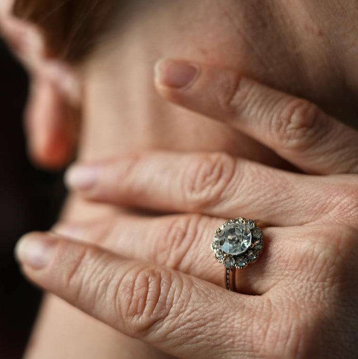 Close-up of a person wearing a pearl earring and diamond ring.