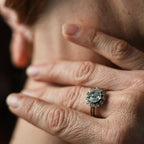 Close-up of a person wearing a pearl earring and diamond ring.