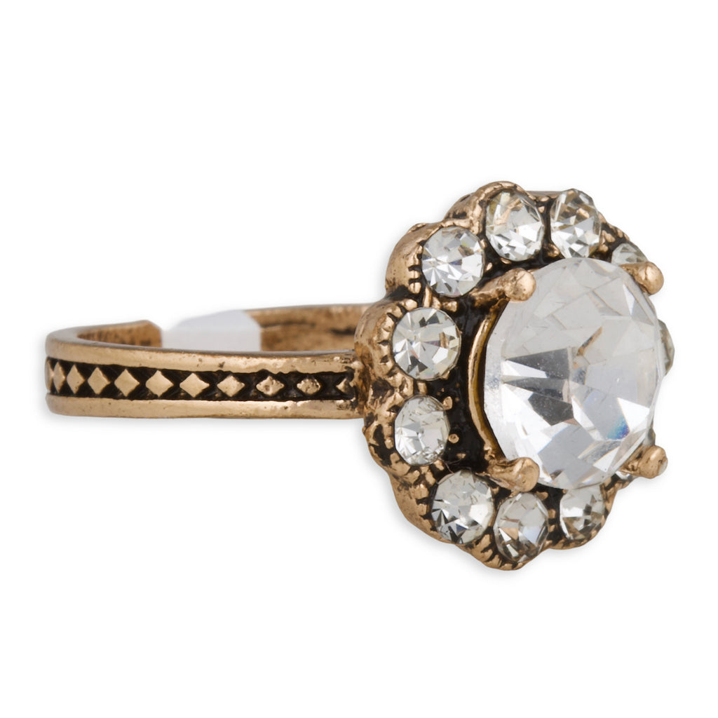 Gold ring with a large central gemstone and smaller stones on a white background