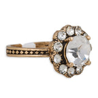Gold ring with a large central gemstone and smaller stones on a white background