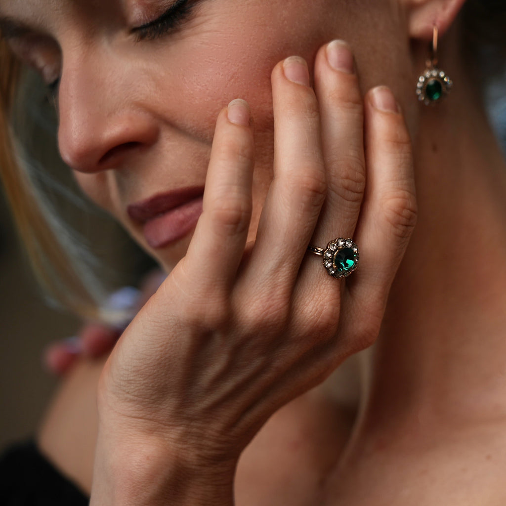 Close-up of a woman's hand with a ring and earring, blurred background