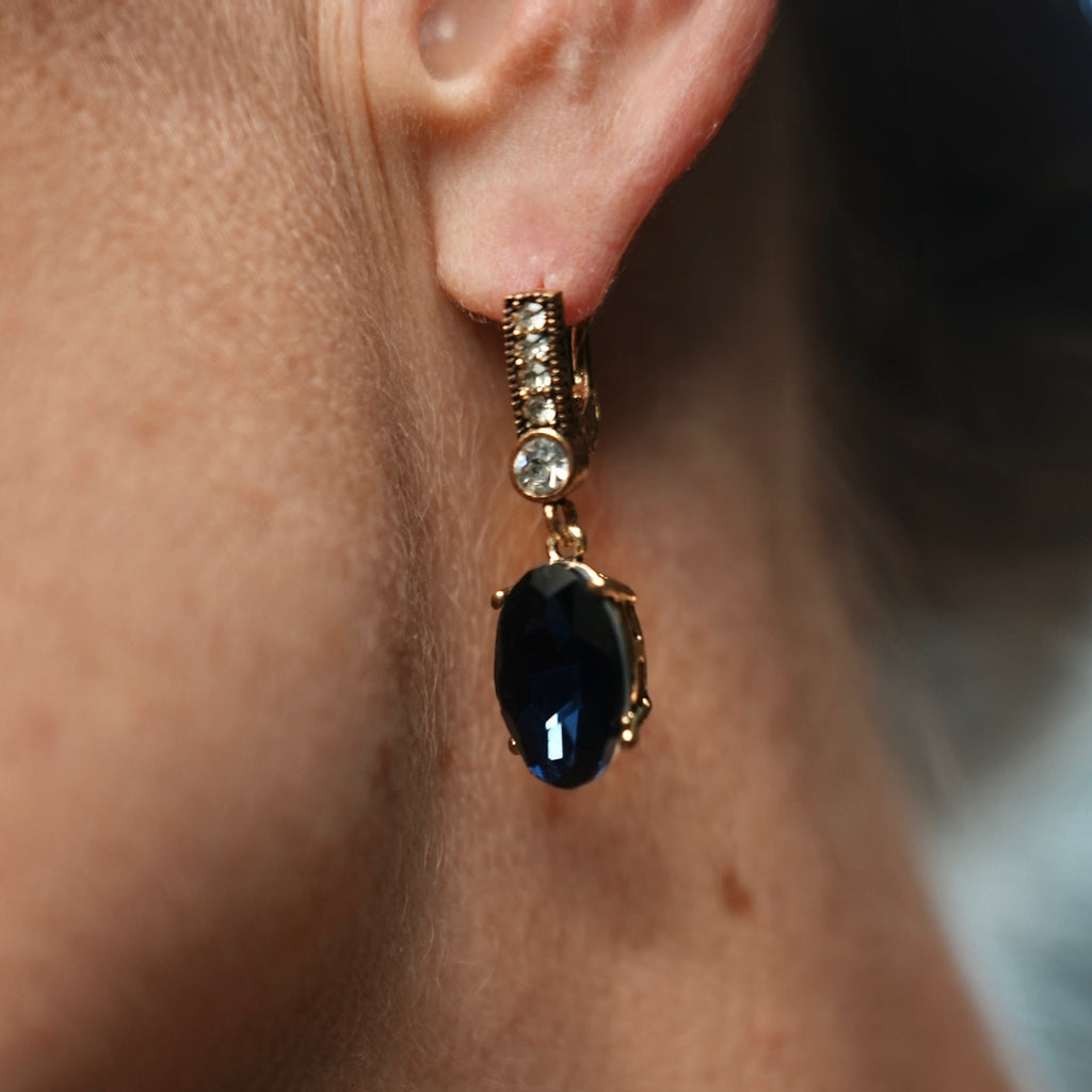 Close-up of an earring with a black gemstone on a person's ear.