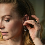 Woman adjusting an earring with a blurred background